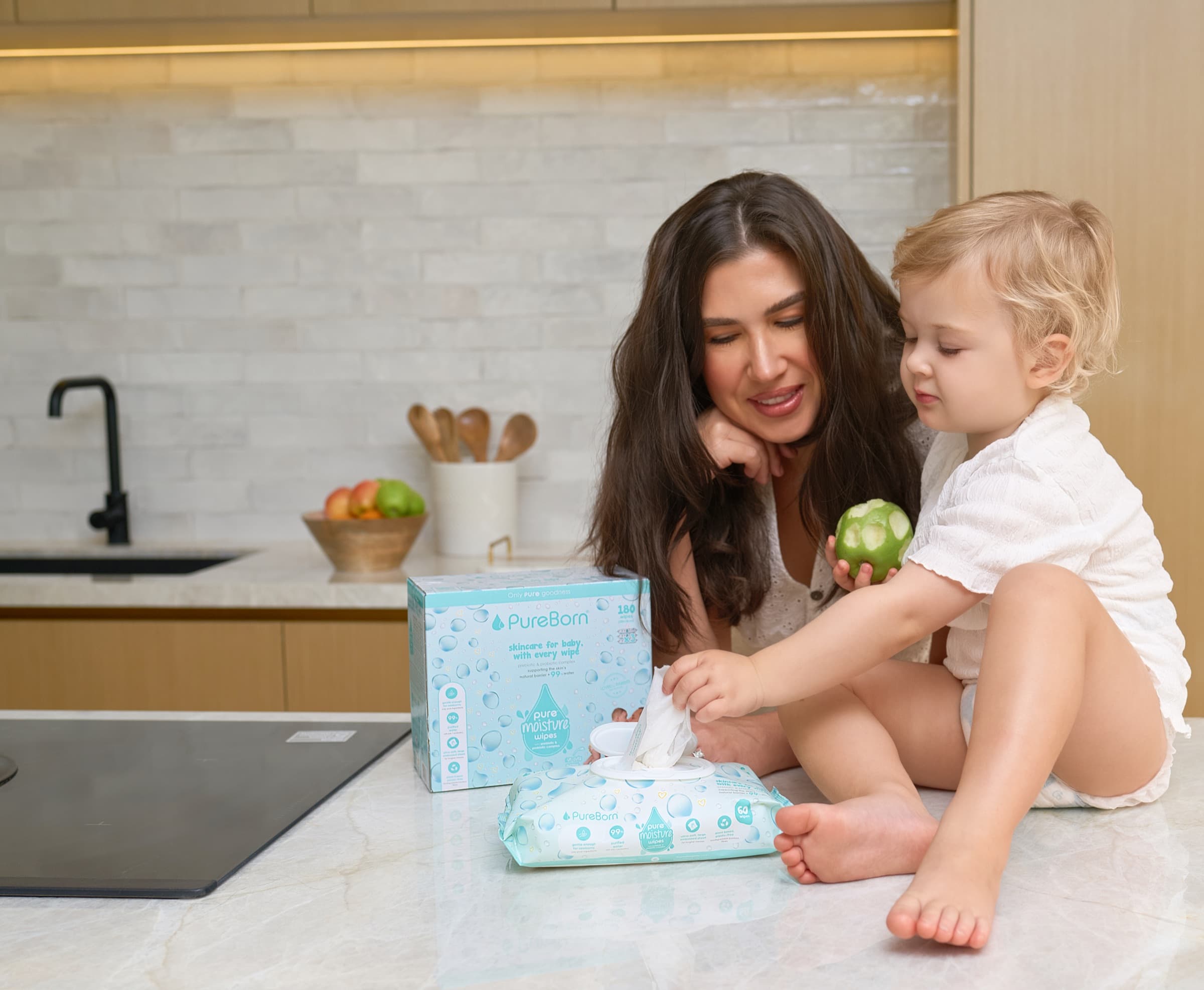 Mother and toddler at a kitchen counter with PureBorn Pure Moisture wipes
